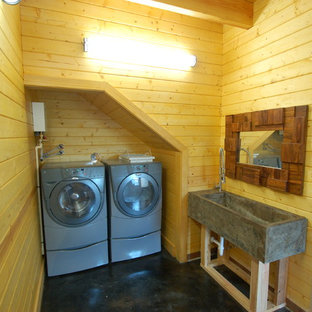 ナッシュビルの中サイズのトラディショナルスタイルのおしゃれな洗濯室 (コンクリートの床、左右配置の洗濯機・乾燥機、黒い床) の写真