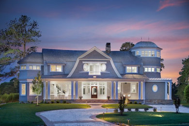 Example of a large beach style beige three-story wood exterior home design in DC Metro with a gambrel roof