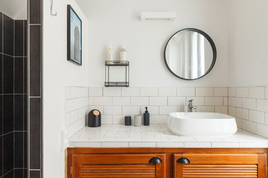 Inspiration for a mid-sized eclectic master bathroom in Paris with a curbless shower, a wall-mount toilet, white tile, ceramic tile, white walls, dark hardwood floors, a console sink, tile benchtops, brown floor and white benchtops.
