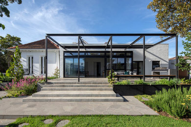 This is an example of a contemporary backyard patio in Melbourne with an outdoor kitchen and a pergola.