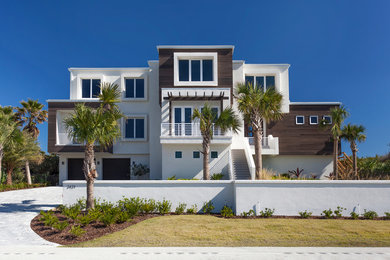 Inspiration for a large contemporary white three-story stucco flat roof remodel in Jacksonville