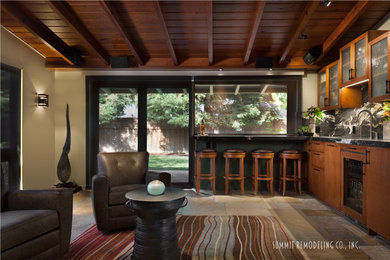 Example of a large minimalist open concept slate floor family room design in San Francisco with a bar and beige walls