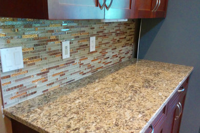 Example of a mid-sized trendy l-shaped open concept kitchen design in Vancouver with an undermount sink, dark wood cabinets, granite countertops, beige backsplash, mosaic tile backsplash, stainless steel appliances and an island