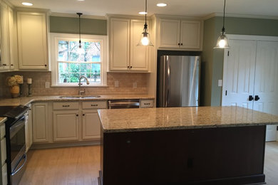 Inspiration for a mid-sized timeless l-shaped porcelain tile and beige floor eat-in kitchen remodel in Other with a double-bowl sink, raised-panel cabinets, white cabinets, granite countertops, beige backsplash, subway tile backsplash, stainless steel appliances and an island