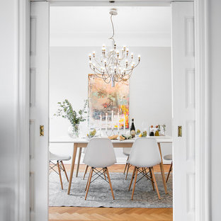 Geschlossenes Skandinavisches Esszimmer mit grauer Wandfarbe, braunem Holzboden und orangem Boden in Malmö