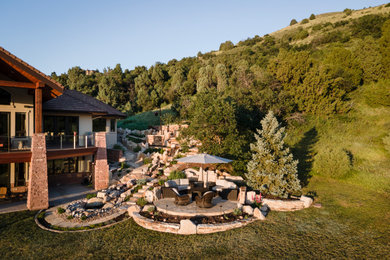 Large elegant backyard stone patio photo in Denver with no cover