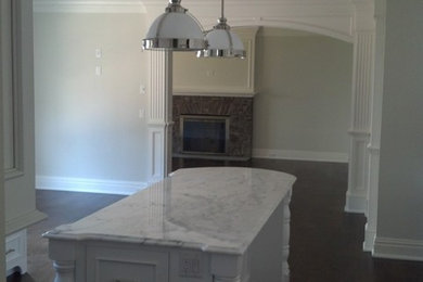 Inspiration for a timeless dark wood floor kitchen remodel in New York with white cabinets, an island, beaded inset cabinets and marble countertops