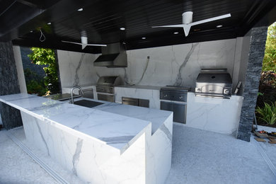 Patio kitchen - contemporary backyard concrete patio kitchen idea in Miami with a roof extension