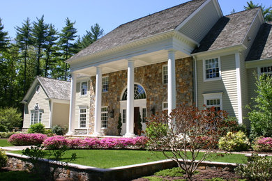 Photo of a mid-sized traditional partial sun front yard stone landscaping in Bridgeport for summer.