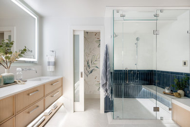 Example of a mid-sized transitional master blue tile and ceramic tile ceramic tile, white floor, double-sink and wallpaper bathroom design in Seattle with light wood cabinets, a bidet, white walls, an undermount sink, quartz countertops, a hinged shower door, white countertops and a floating vanity
