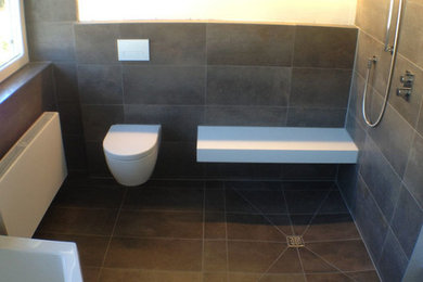 Großes Modernes Duschbad mit Einbaubadewanne, braunen Fliesen, Steinplatten, weißer Wandfarbe, bodengleicher Dusche, Wandtoilette, Marmorboden, offener Dusche und braunem Boden in Köln