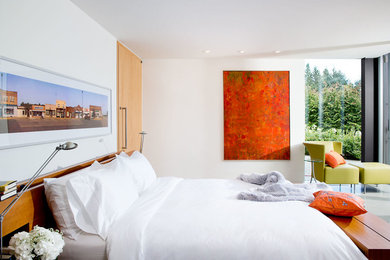 Photo of a mid-sized contemporary master bedroom in Vancouver with white walls and concrete floors.