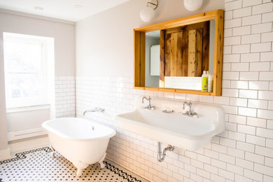 Photo of a transitional bathroom in Philadelphia with a claw-foot tub, subway tile and a wall-mount sink.