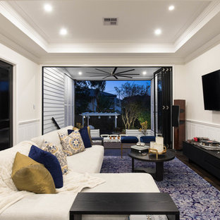 Transitional enclosed family room in Brisbane with white walls, dark hardwood floors and a wall-mounted tv.