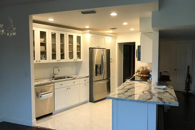 Open concept kitchen - mid-sized transitional galley marble floor and white floor open concept kitchen idea in Miami with glass-front cabinets, white cabinets, granite countertops, no island, gray countertops, a double-bowl sink and stainless steel appliances