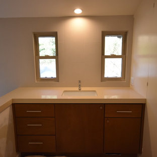 Idee per una grande stanza da bagno padronale moderna con ante lisce, ante in legno scuro, vasca freestanding, doccia ad angolo, WC monopezzo, piastrelle beige, piastrelle in gres porcellanato, pareti beige, pavimento con piastrelle di ciottoli, lavabo sottopiano, top in rame e pavimento beige