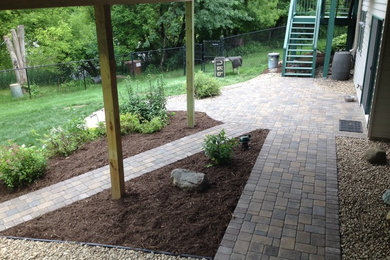 Patio - large transitional backyard stone patio idea in Minneapolis with a roof extension