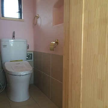 色漆喰とタイルのトイレ