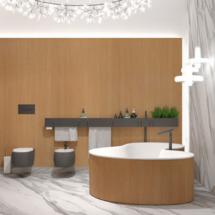 Immagine di una stanza da bagno padronale scandinava di medie dimensioni con ante lisce, ante bianche, vasca freestanding, doccia aperta, WC sospeso, piastrelle arancioni, lastra di pietra, pareti arancioni, pavimento in marmo, lavabo da incasso, top in superficie solida e pavimento grigio
