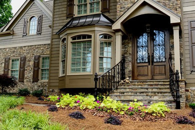 Large transitional brown three-story wood exterior home photo in Atlanta with a hip roof