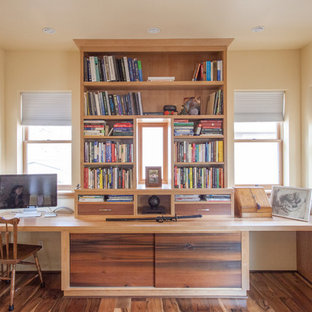 Photo of a small modern home office and library in Other with a reading nook, yellow walls, dark hardwood flooring, no fireplace and brown floors.