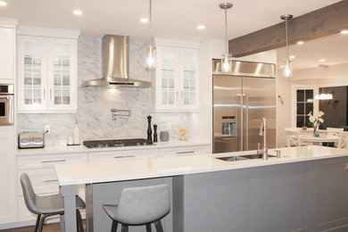 Eat-in kitchen - mid-sized transitional single-wall medium tone wood floor and brown floor eat-in kitchen idea in Vancouver with an undermount sink, recessed-panel cabinets, quartz countertops, gray backsplash, marble backsplash, stainless steel appliances, an island, white countertops and white cabinets