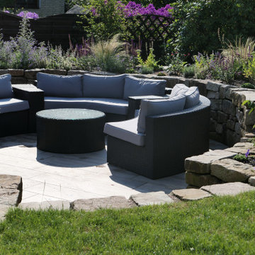 Insektenfreundlicher Garten mit Natursteinmauern und tiefergelegtem Sitzplatz