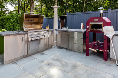 Large traditional backyard patio in New York with an outdoor kitchen, natural stone pavers and no cover.