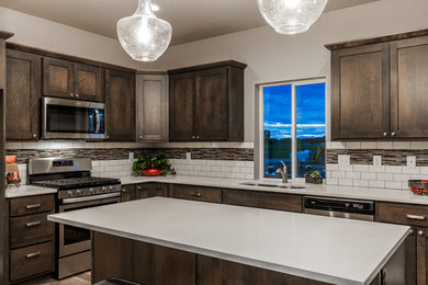 Open concept kitchen - transitional l-shaped laminate floor and gray floor open concept kitchen idea in Other with an undermount sink, shaker cabinets, gray cabinets, quartzite countertops, white backsplash, ceramic backsplash, stainless steel appliances, an island and white countertops