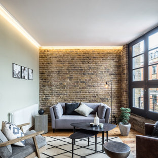 Photo of an industrial open plan living room in London with medium hardwood flooring, no fireplace and no tv.