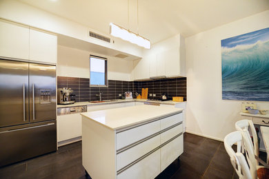 Photo of a mid-sized contemporary l-shaped eat-in kitchen in Sydney with a single-bowl sink, flat-panel cabinets, white cabinets, quartz benchtops, black splashback, ceramic splashback, stainless steel appliances, ceramic floors and with island.