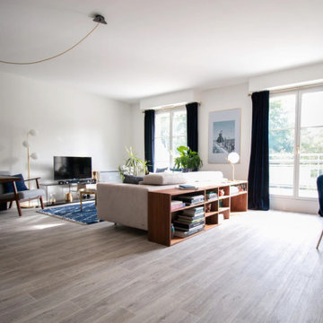 Vue d'ensemble pièce de vie avec canapé gris et son espace de rangement en bois