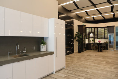 Example of a small trendy single-wall light wood floor and gray floor kitchen design in San Francisco with an undermount sink, flat-panel cabinets, white cabinets, quartz countertops, gray backsplash, stone slab backsplash, paneled appliances, no island and gray countertops