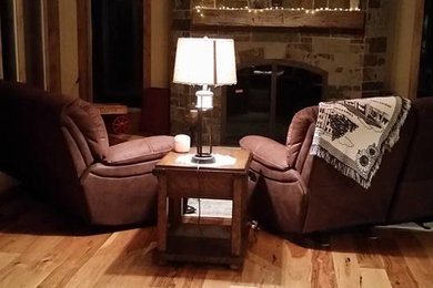 Photo of a mid-sized arts and crafts sunroom in Wichita with light hardwood floors, a standard fireplace, a stone fireplace surround and brown floor.