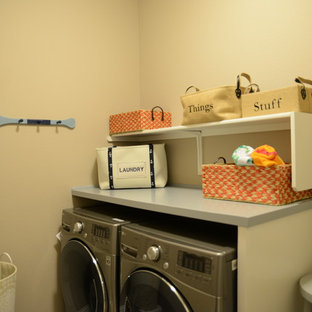 This is an example of a small classic single-wall separated utility room in Austin with raised-panel cabinets, white cabinets, wood worktops, beige walls, ceramic flooring and a side by side washer and dryer.