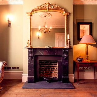 Ispirazione per un piccolo soggiorno vittoriano chiuso con sala formale, pavimento in legno massello medio, camino classico, cornice del camino in pietra e nessuna TV