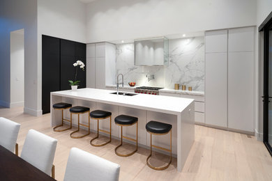 Design ideas for a large contemporary l-shaped eat-in kitchen in Vancouver with an undermount sink, flat-panel cabinets, white cabinets, quartz benchtops, white splashback, stone slab splashback, stainless steel appliances, light hardwood floors, with island, beige floor and white benchtop.