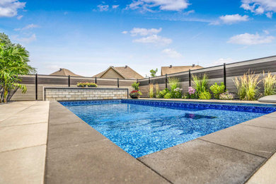 Example of a mid-sized cottage chic backyard stone and rectangular pool design in Ottawa