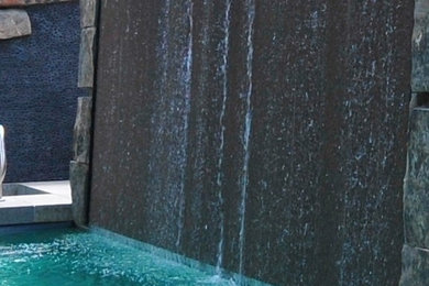 Inspiration for a backyard stone and custom-shaped pool fountain remodel in Denver