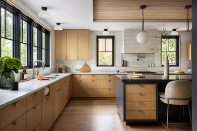 Example of a minimalist l-shaped medium tone wood floor, brown floor, tray ceiling and wood ceiling kitchen design in New York with an undermount sink, flat-panel cabinets, medium tone wood cabinets, white backsplash, stainless steel appliances, an island and white countertops