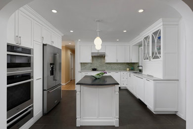 Mid-sized transitional u-shaped separate kitchen in DC Metro with a single-bowl sink, flat-panel cabinets, white cabinets, quartz benchtops, green splashback, ceramic splashback, stainless steel appliances, porcelain floors, with island, brown floor and white benchtop.