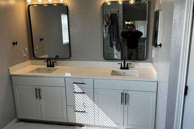 Mid-sized cottage master ceramic tile, brown floor and double-sink bathroom photo in Cincinnati with shaker cabinets, white cabinets, gray walls, an undermount sink, quartz countertops, multicolored countertops and a built-in vanity