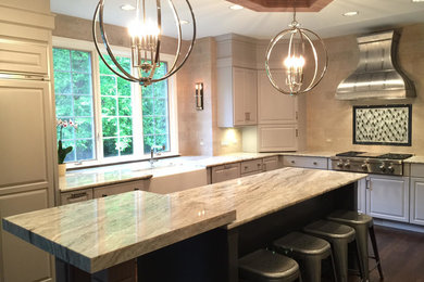 Inspiration for a large transitional u-shaped dark wood floor and brown floor enclosed kitchen remodel in Chicago with a farmhouse sink, raised-panel cabinets, gray cabinets, quartzite countertops, beige backsplash, stone tile backsplash, stainless steel appliances, an island and beige countertops