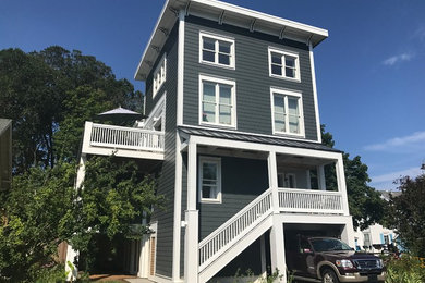 Example of a mid-sized classic gray three-story vinyl house exterior design in Other with a hip roof