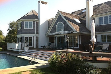 Example of a mid-sized beach style backyard stone and rectangular natural pool design in New York