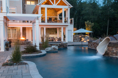 Design ideas for a large eclectic backyard custom-shaped natural pool in DC Metro with a water slide and concrete pavers.