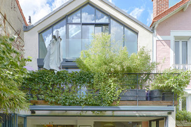 Idées déco pour une façade de maison contemporaine en verre à trois étages et plus avec un toit à deux pans.