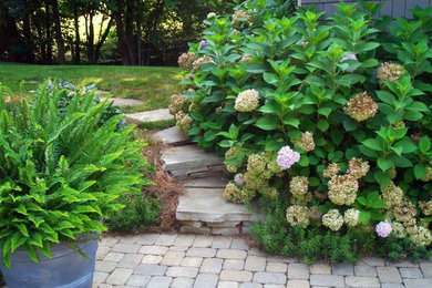 This is an example of a mid-sized transitional partial sun backyard concrete paver landscaping in Other.