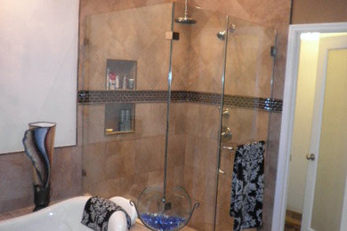 Inredning av ett modernt badrum, med brun kakel och dusch med gångjärnsdörr