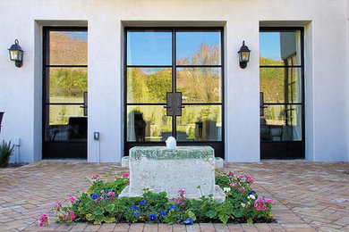 Entryway - huge transitional brick floor entryway idea in Phoenix with white walls and a glass front door
